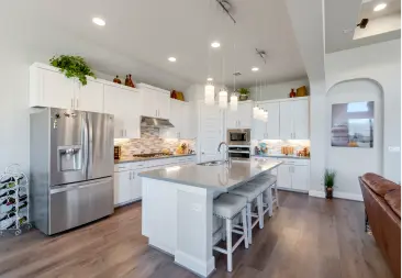 bright-spacious-kitchen-with-modern-appliances-an-island-and-bar-stools.